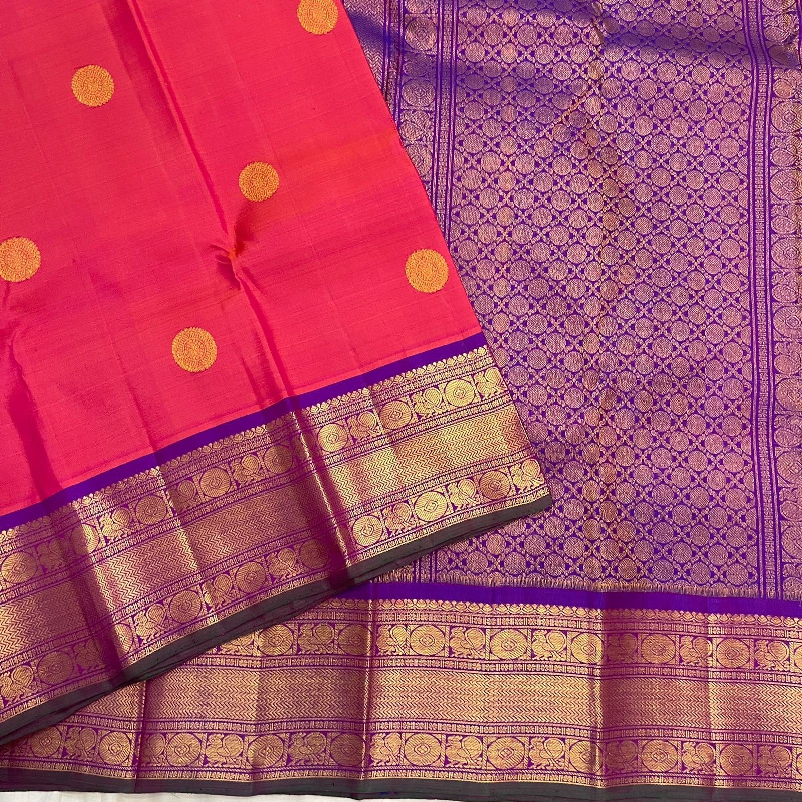 Amethyst purple gold zari pallu detail on coral-red saree