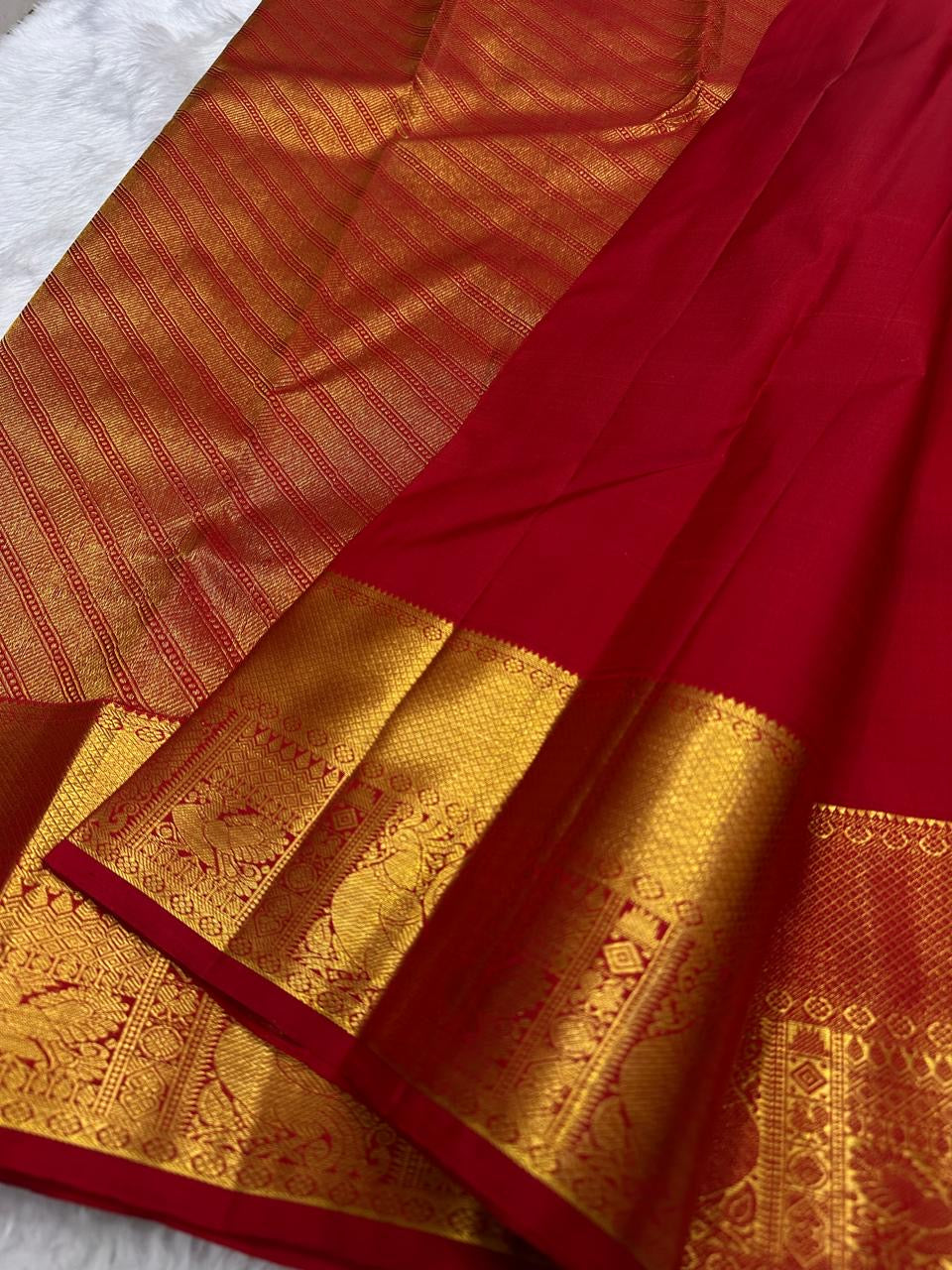 Full red Kanchi Pattu Mayil Chakram saree folded view