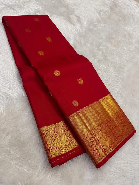 Gold zari peacock-and-bird pallu detail on red saree
