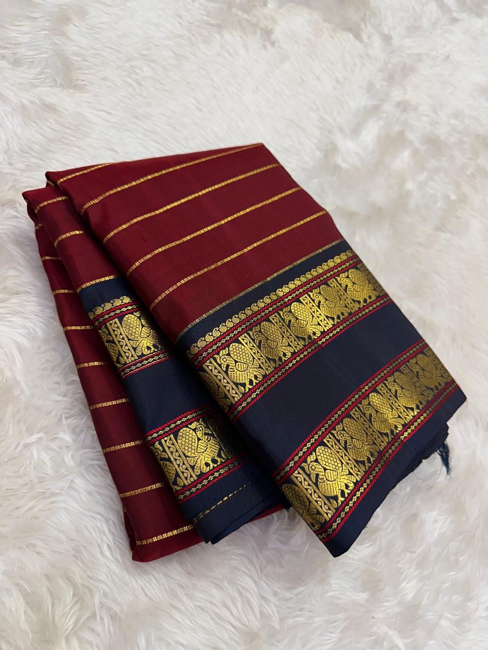 Pillar box red Kanchi Pattu saree, midnight navy Rettapet border detail