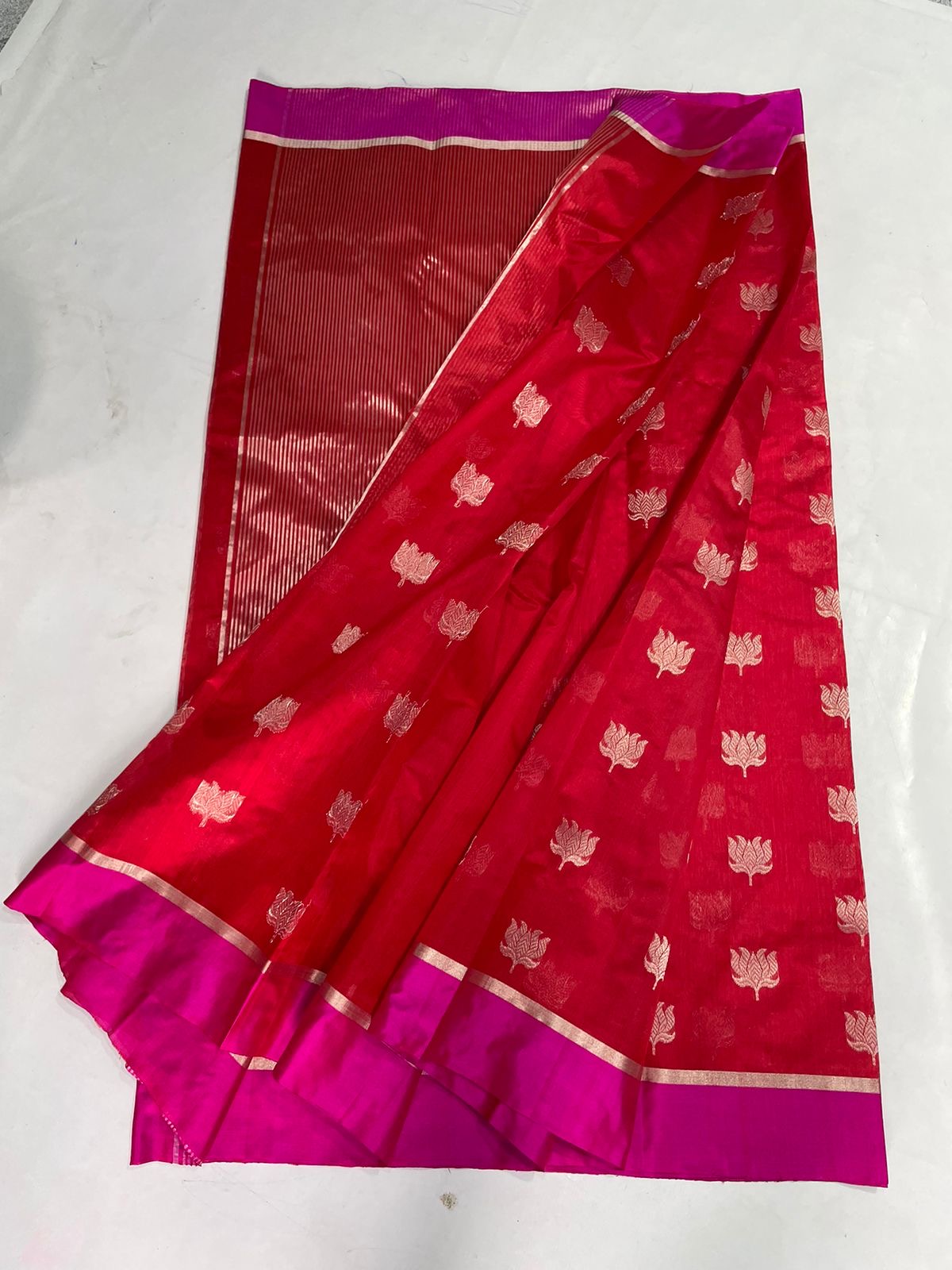 Vermilion Red and Rani Pink Pattu Silk Chanderi saree detail with repeating gold-toned floral buttas.