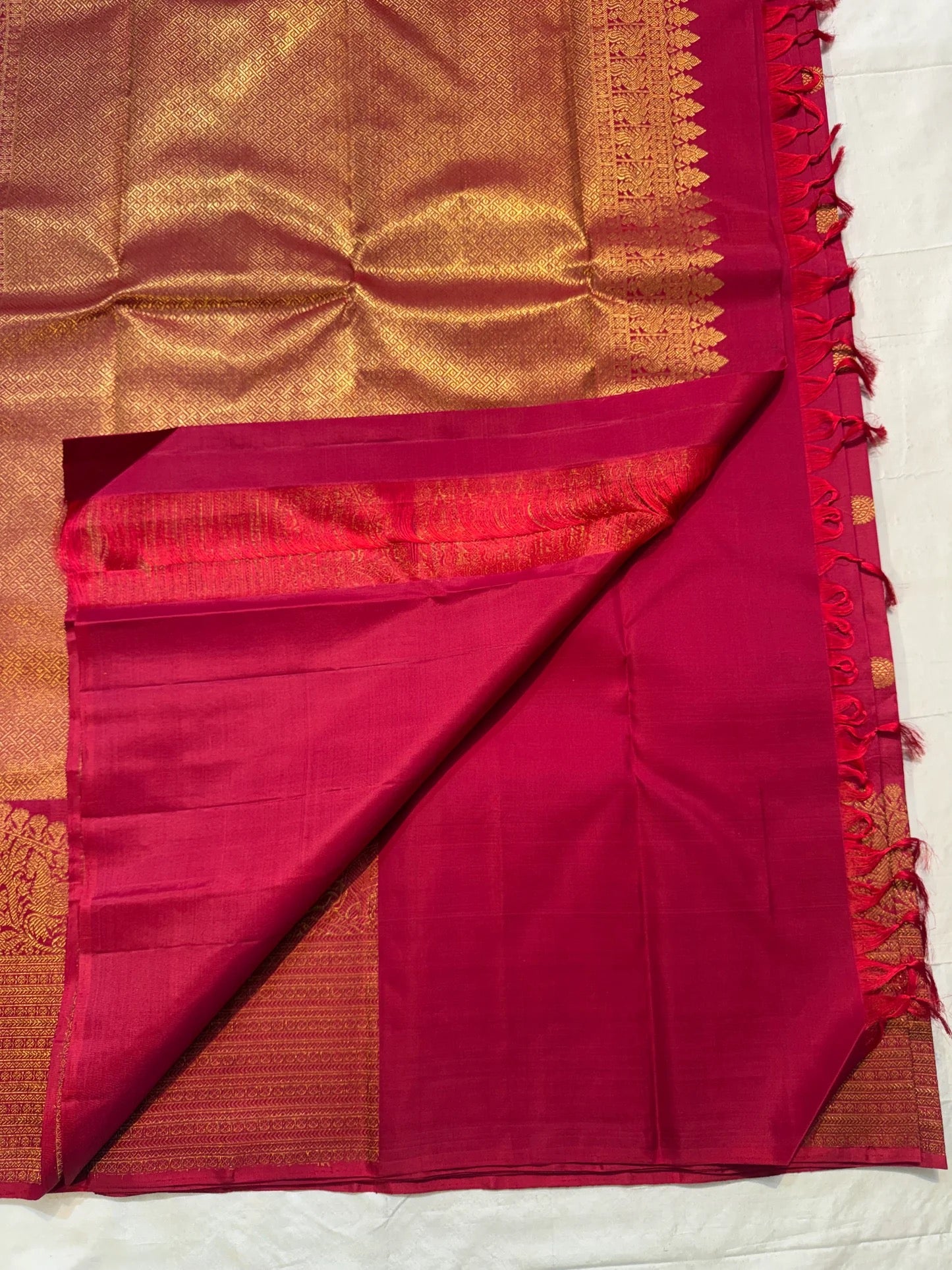 Close view of Red Deep Pink double-shade Kanchipuram silk with dense geometric gold zari pallu and figured border.