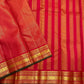 Close view of red silk saree border with gold zari pattern bands and forest green selvedge along the edge.