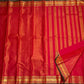 Full length red Kanchipuram silk saree laid flat with striped pallu and wide gold zari borders, available in the USA.