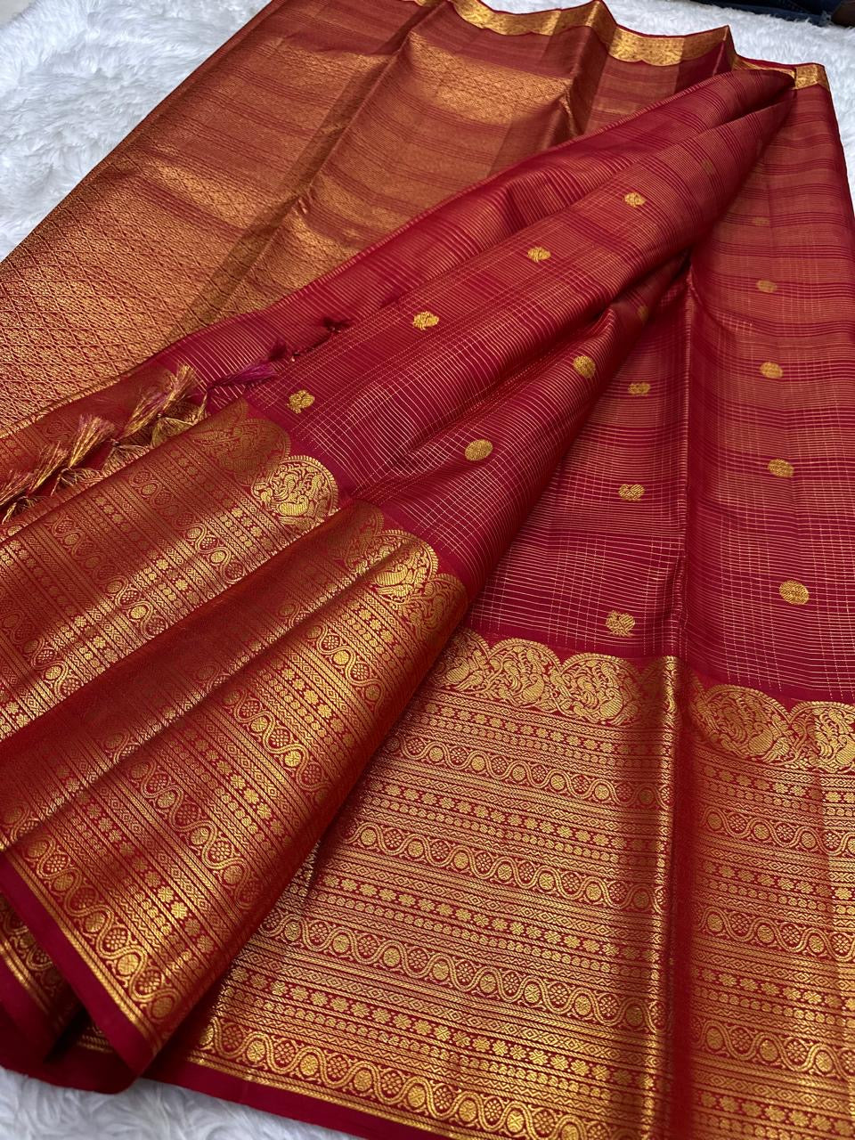 Broad classic-gold ornamental registers framing the vivid red Kanchipuram body.