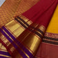 Close-up of red pallu with gold zari woven floral pattern and border bands in maroon, gold, and purple.
