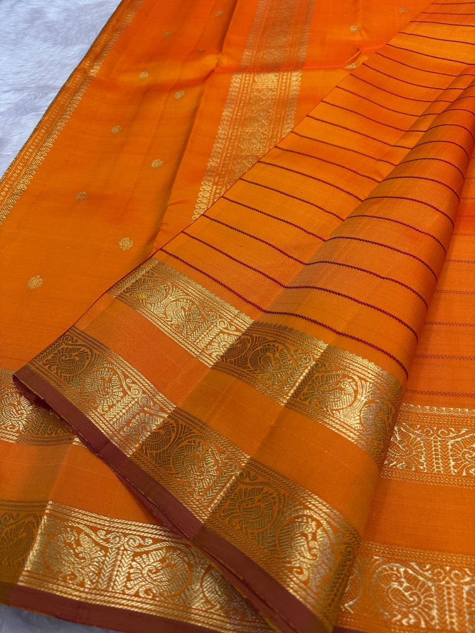 Kanchipattu silk saree in sunset orange with reddish pink border Veldhari Rettapet weave traditional zari detail