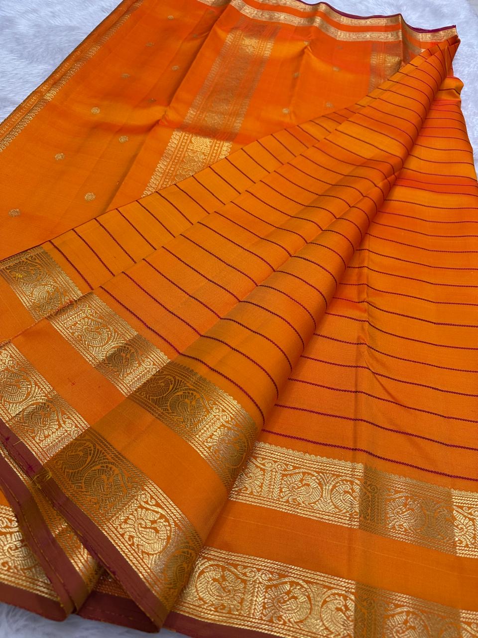 Kanchipattu silk saree in sunset orange with reddish pink border Veldhari Rettapet weave traditional zari detail