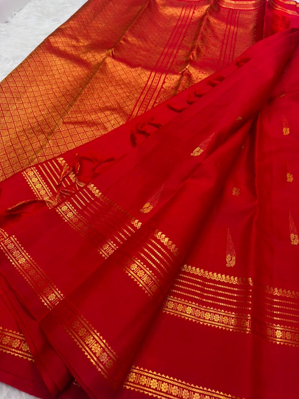 Handwoven Rettapet border showing repeated floral rosettes, fine dotted bands and classic-gold geometric registers.