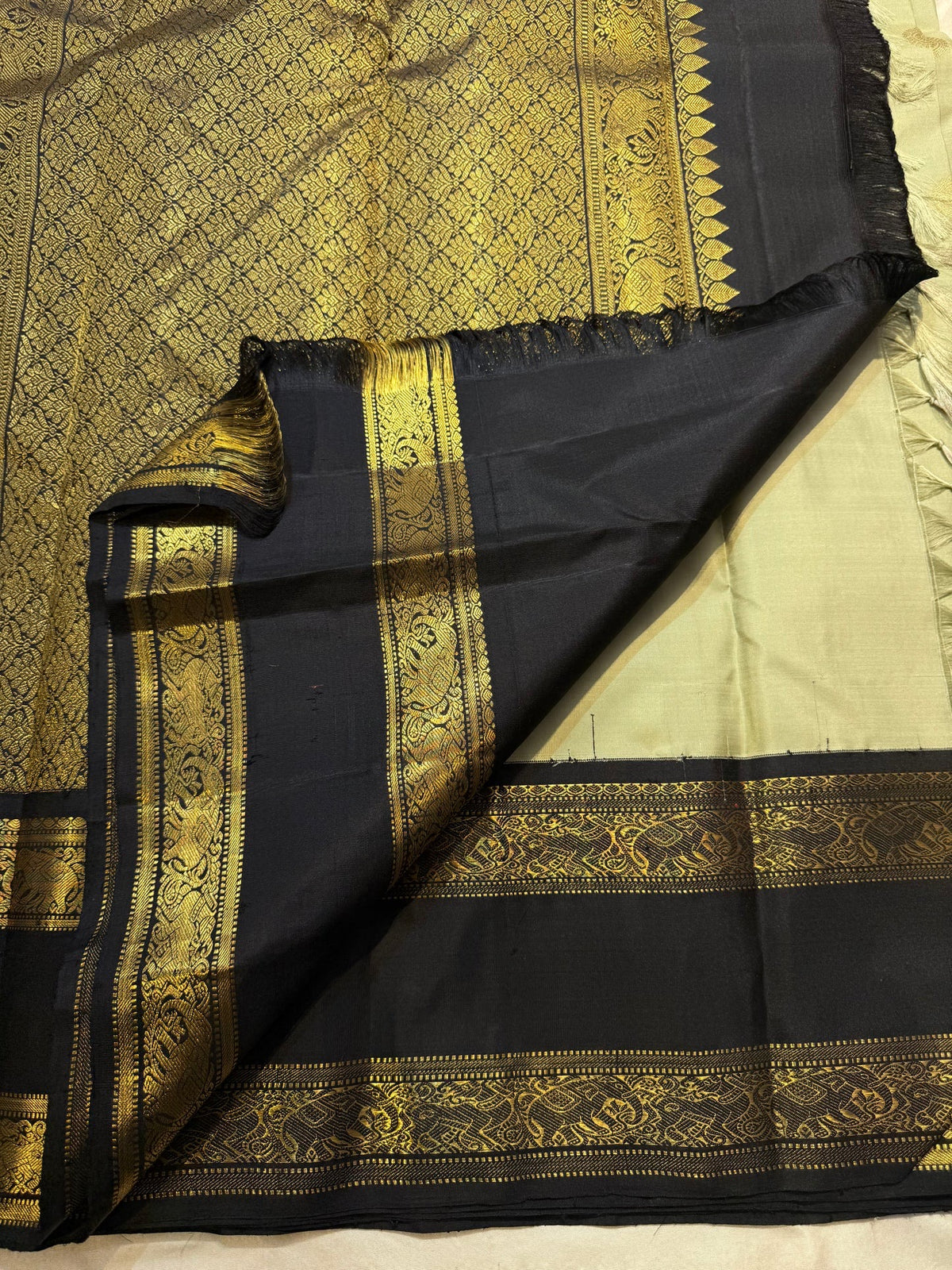 Close-up of the gold zari on the sage green Rettapet Kanjivaram saree