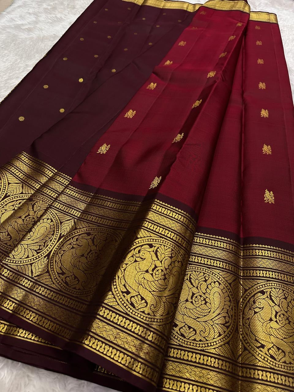 Rich burgundy red Kanjeevaram saree with deep maroon korvai border – detail view