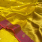 Turmeric yellow Pattu silk Chanderi saree showing gold-toned buttas, raspberry pink border and golden woven pallu