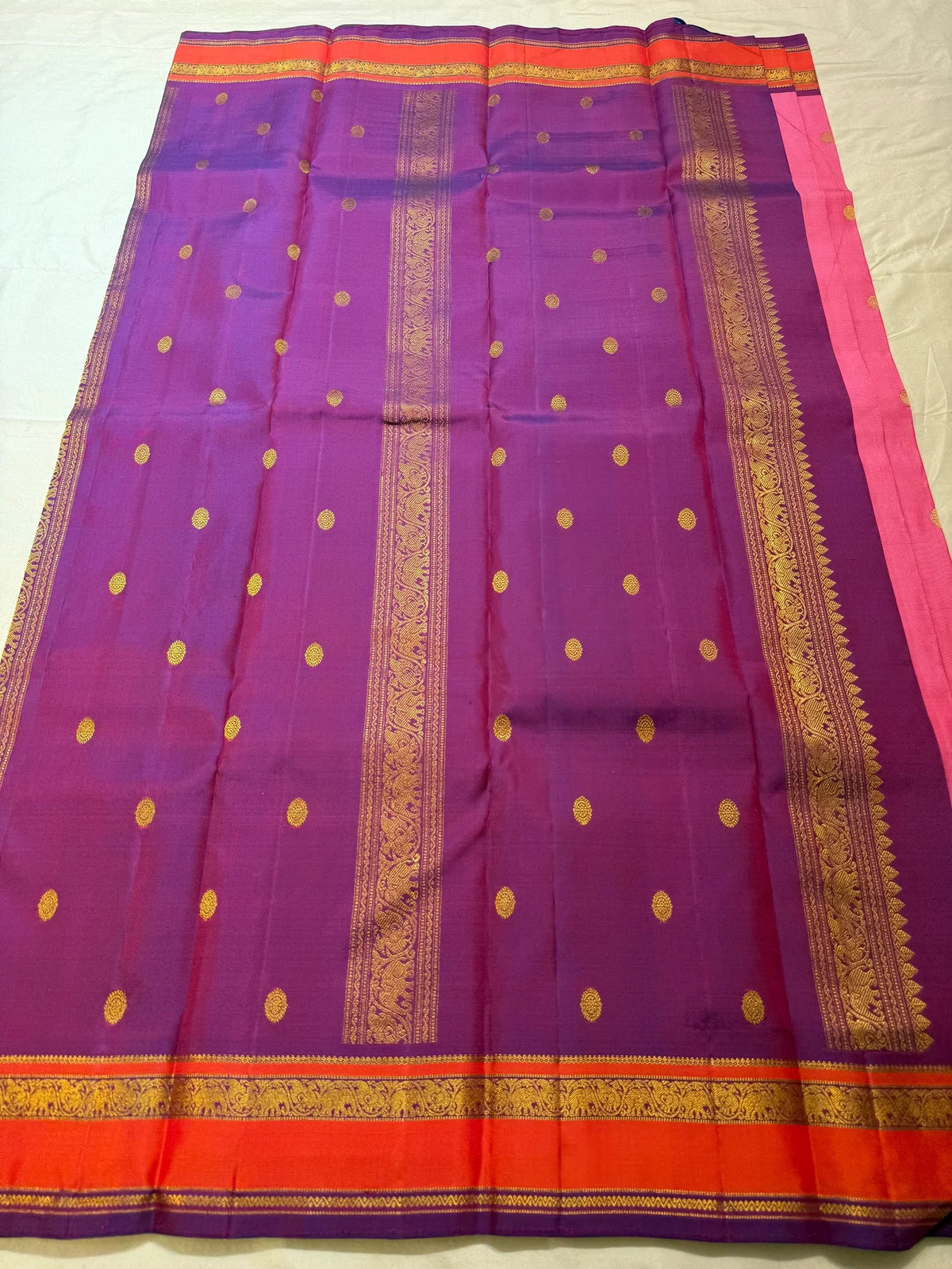 Rose pink Kanchipuram saree with coral-orange and purple contrast border