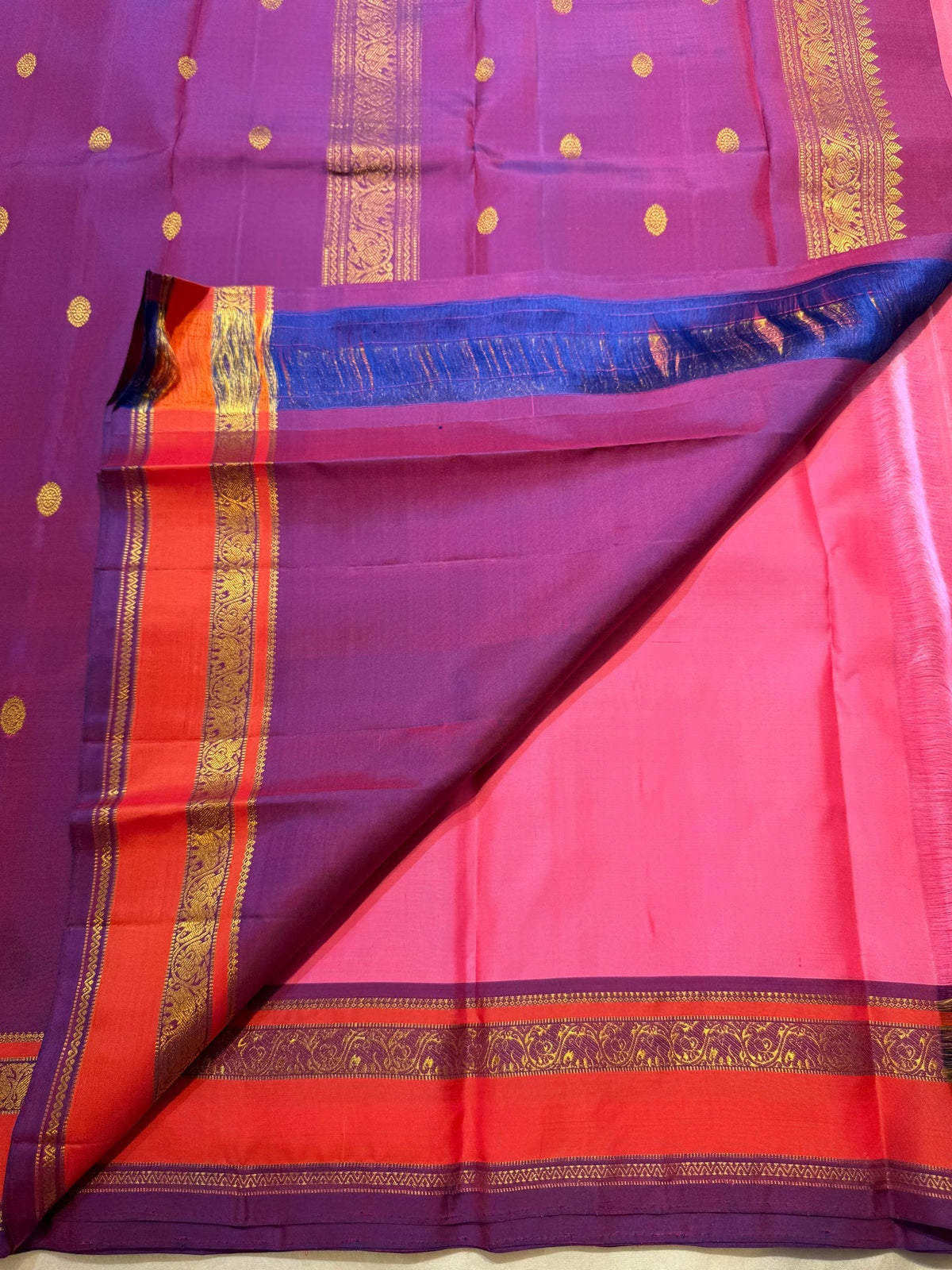 Full view of the rose pink Kanchipuram Butta saree with coral-orange and purple border
