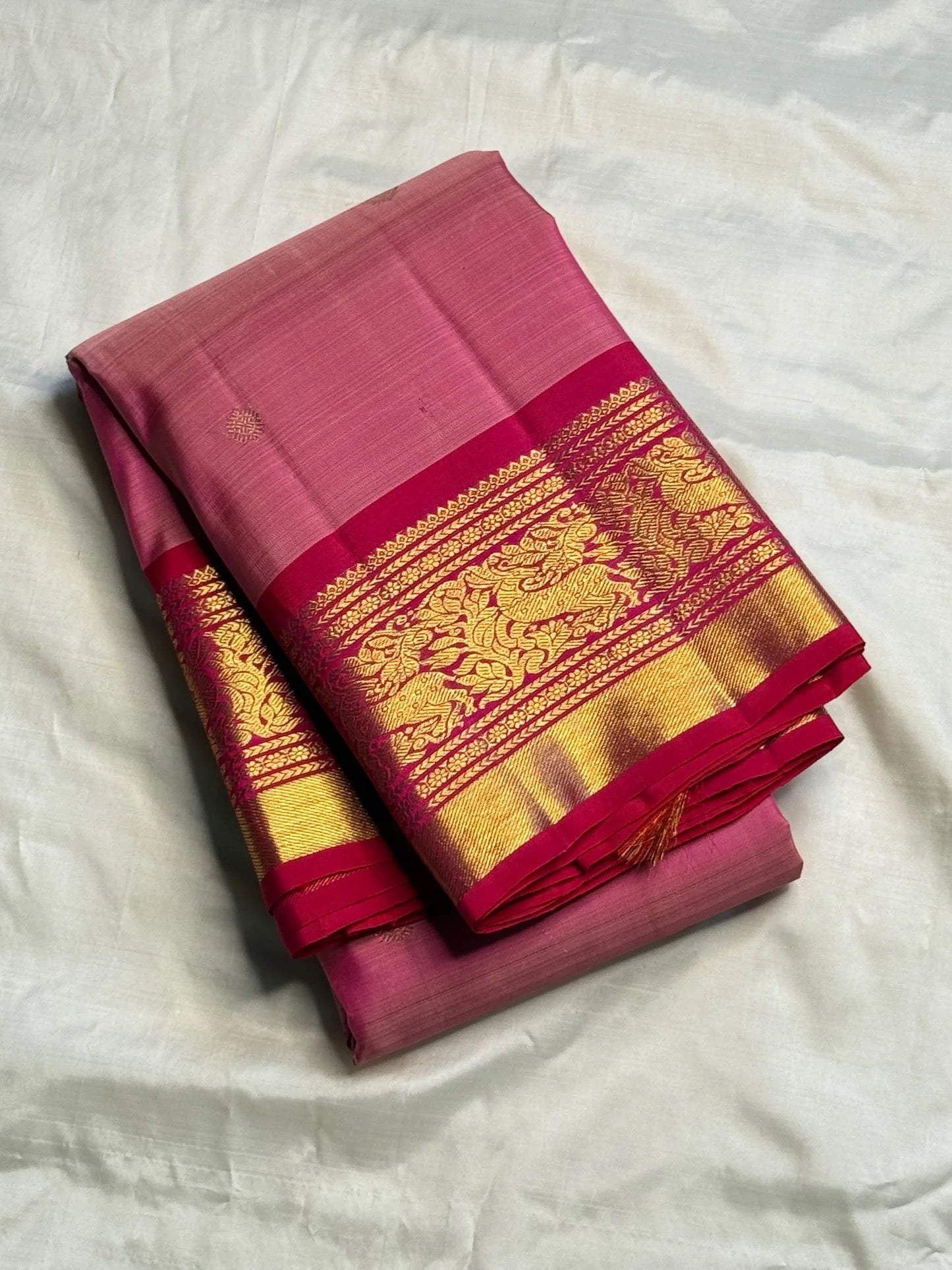 Close-up of delicately handwoven zari buttas on rose pink Kanjeevaram Korvai silk saree