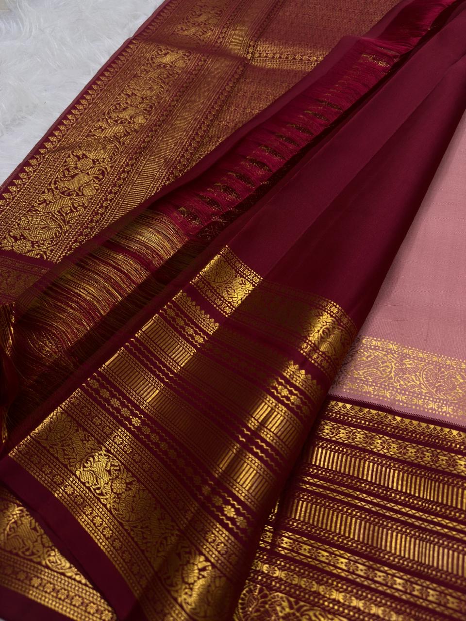 Close-up of antique-gold zari buttas on dusty rose Kanchi Pattu saree body