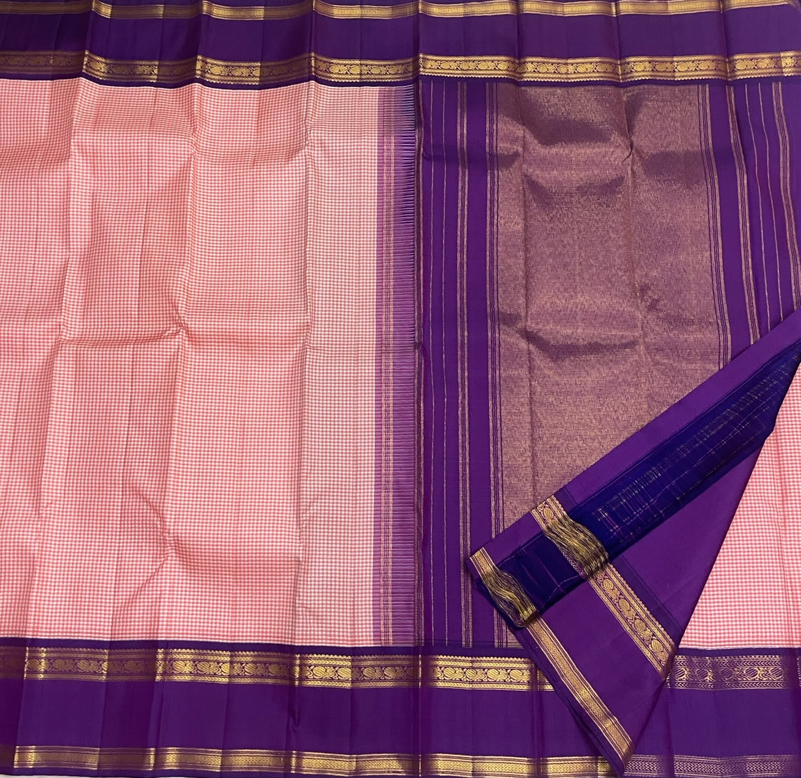 Close-up of the royal purple border with gold zari kasu (coin) motifs on the rose pink Kanchi Pattu saree.