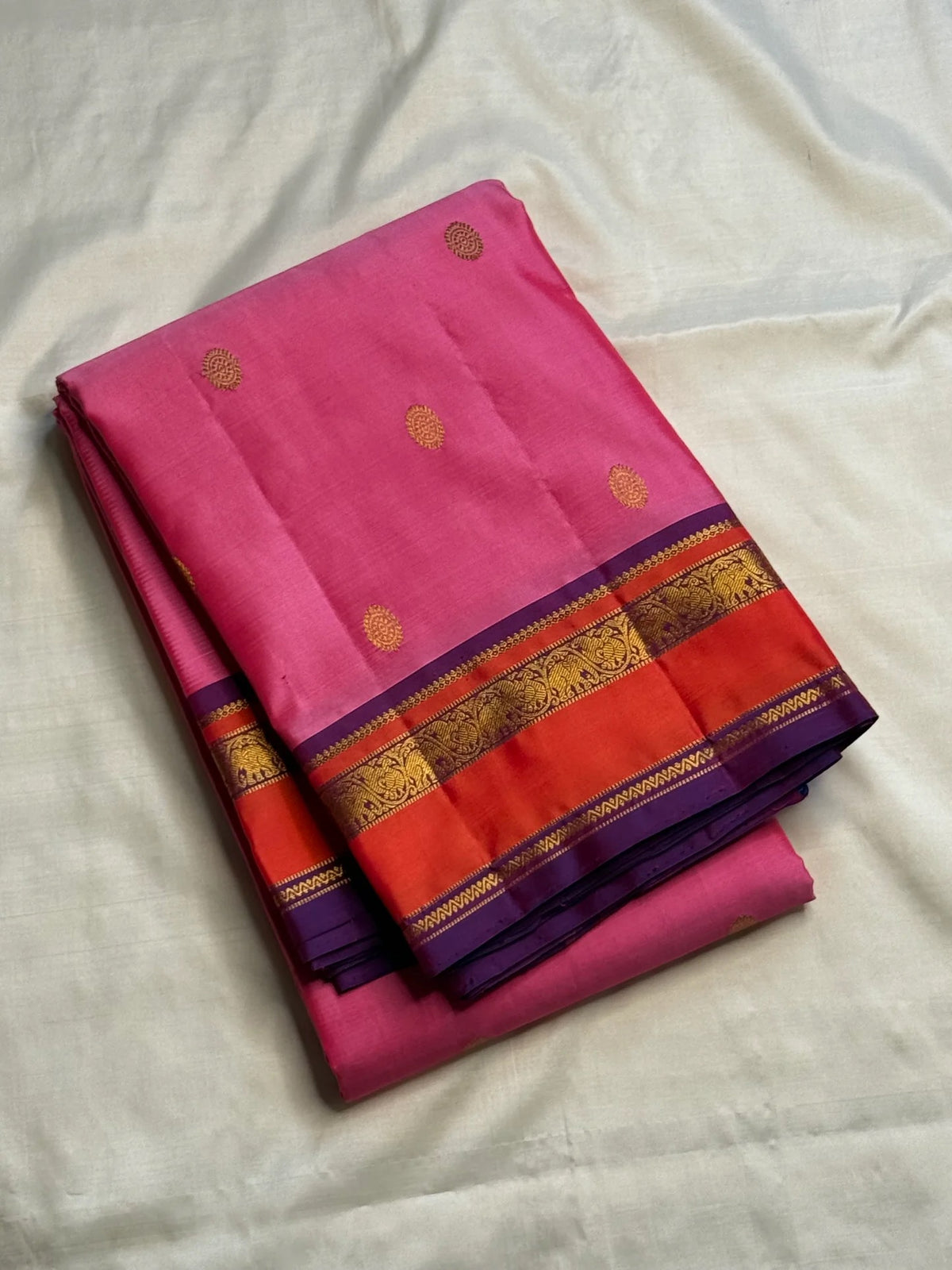 Rose pink Pure Silk Kanjivaram saree draped, showing the zari-woven kamalam buttas