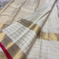 Narrow vivid rose-pink selvedge along the elaborate gold zari border of ivory silk.
