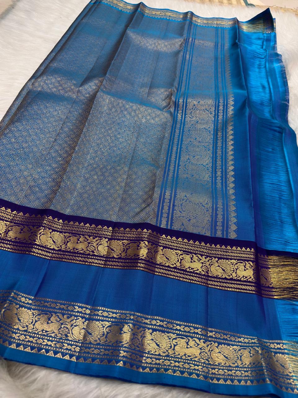 Royal azure blue handwoven pure silk Rettapet saree with silver zari buttas and purple border, styled view