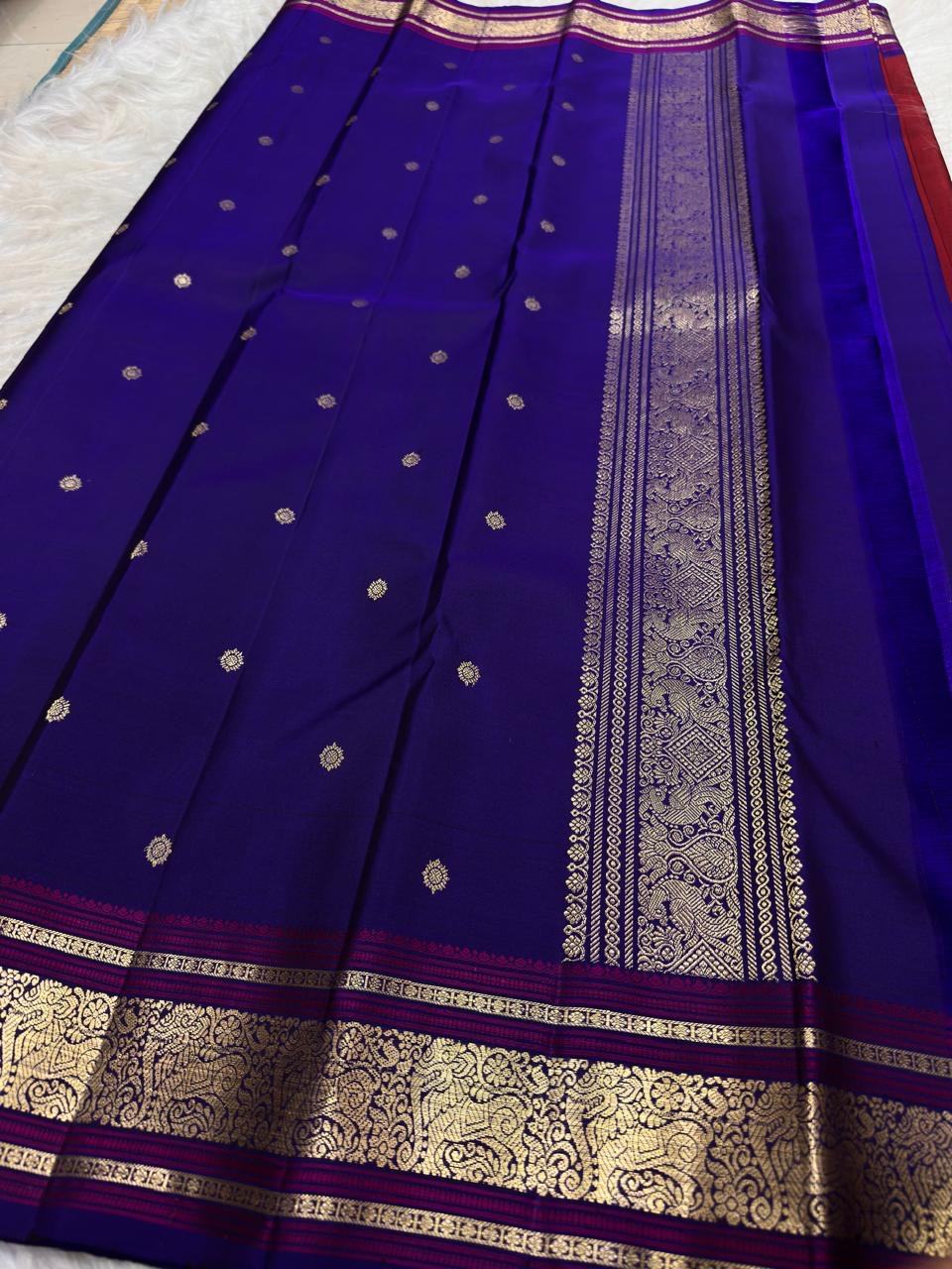 Pallu with woven gold zari on royal blue and deep cherry red Kanchipuram silk saree