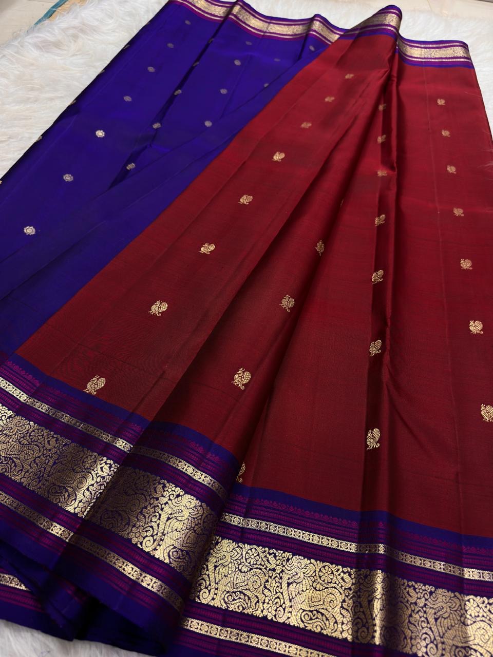 Deep cherry red handwoven Pure Silk Kanchipuram saree with royal blue contrast, mayil buttas and zari border