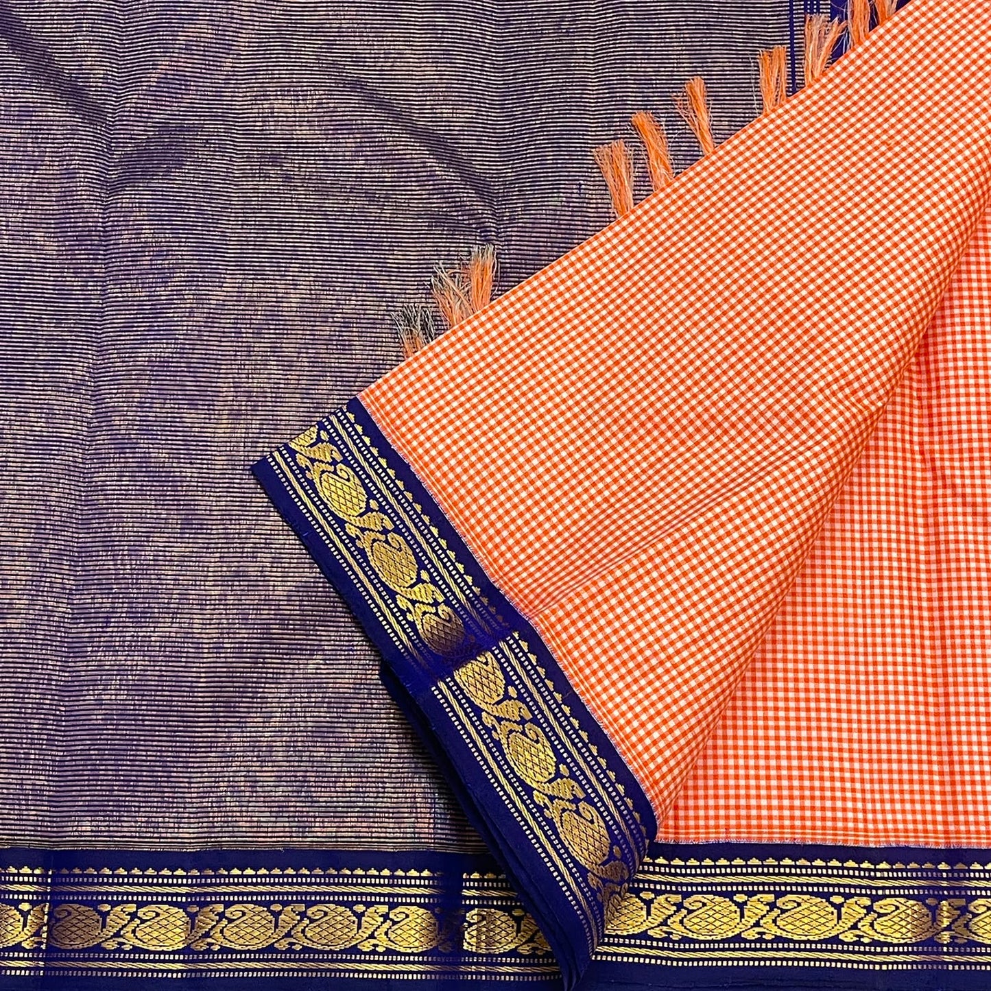 Royal blue floral vine border detail on the soft peach ivory Kanchipuram saree