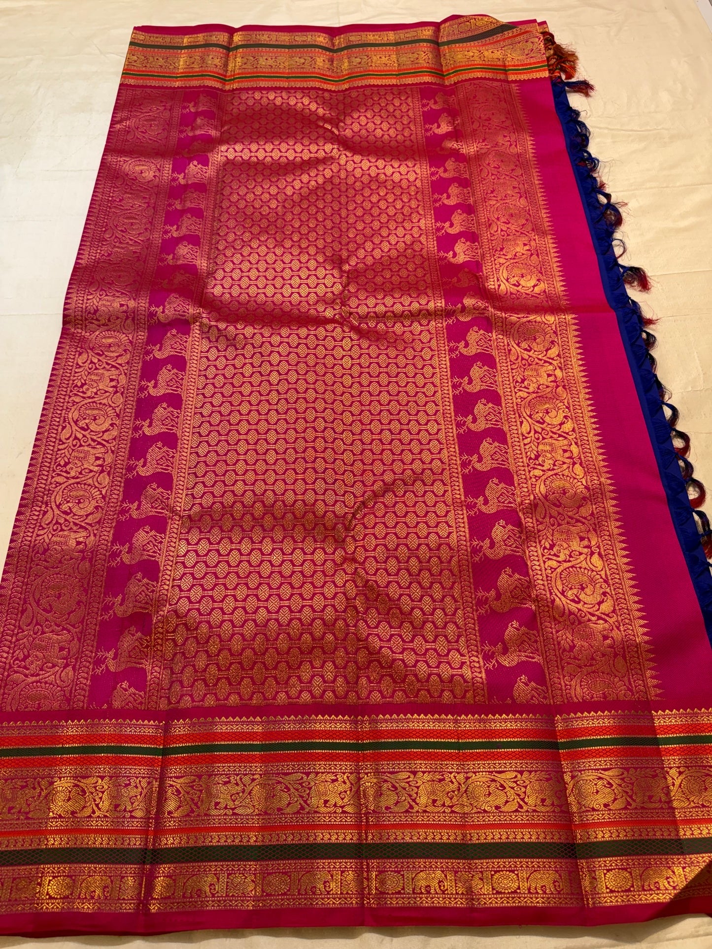 Full Royal Blue Kanchipuram Korvai saree with gold body motifs and richly stacked Rani Pink zari border.