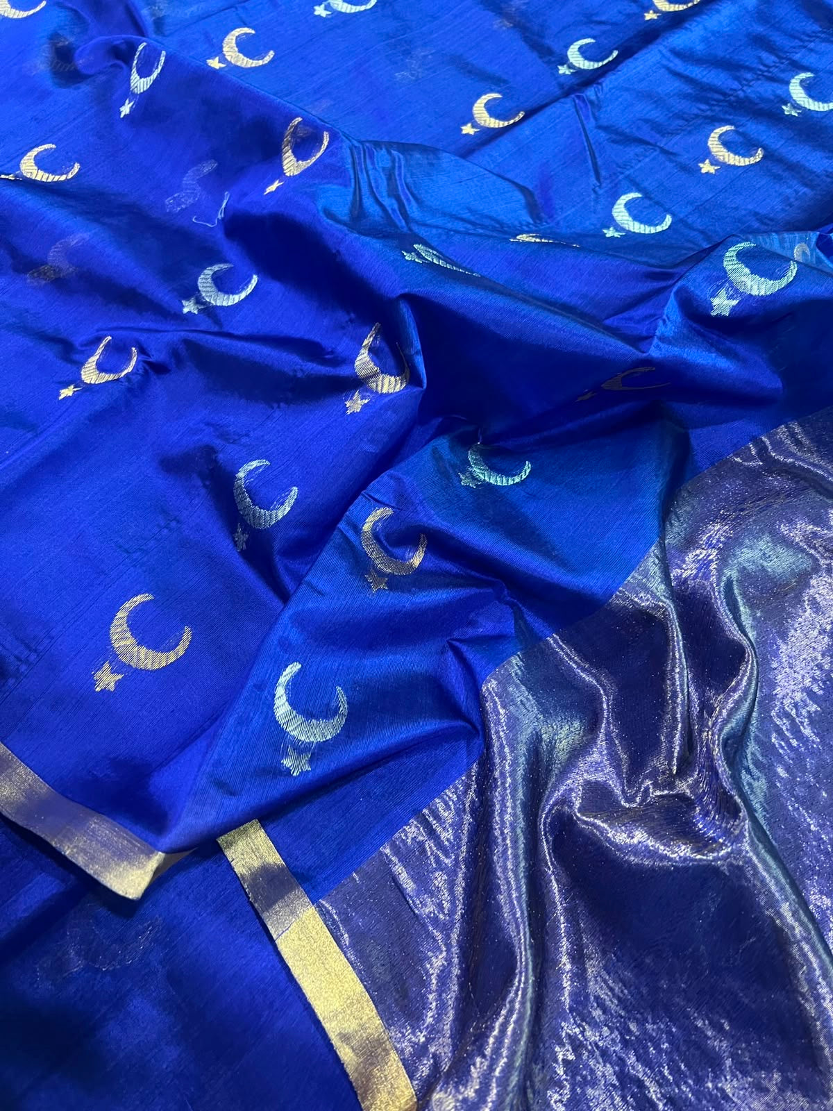 Close-up of gold zari buttas and striped border on royal blue Chanderi silk saree