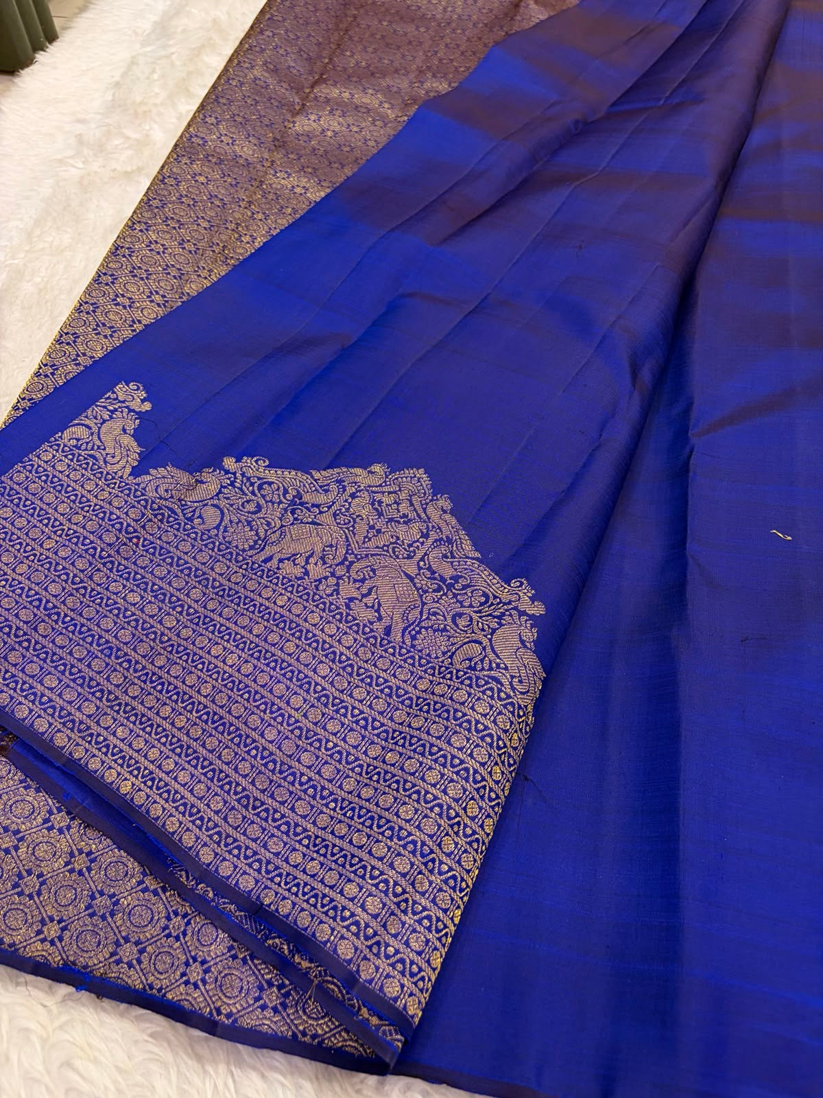 Royal Blue Kanchi Pattu silk saree body close-up showing gold zari floral butta motifs