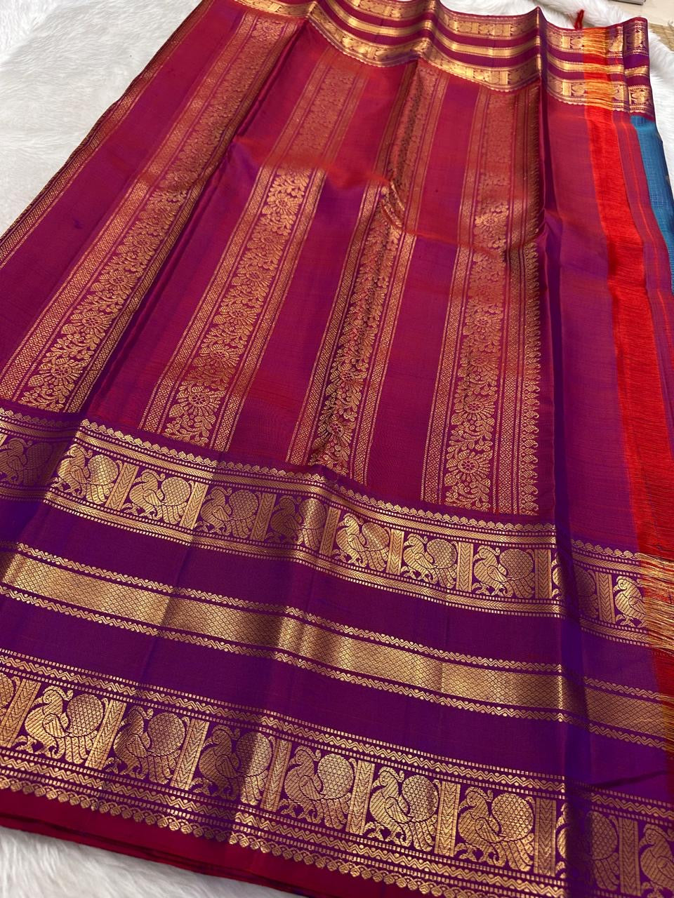Magenta pallu with gold zari elephant and peacock motifs on royal blue Kancheepuram Varisaipet saree