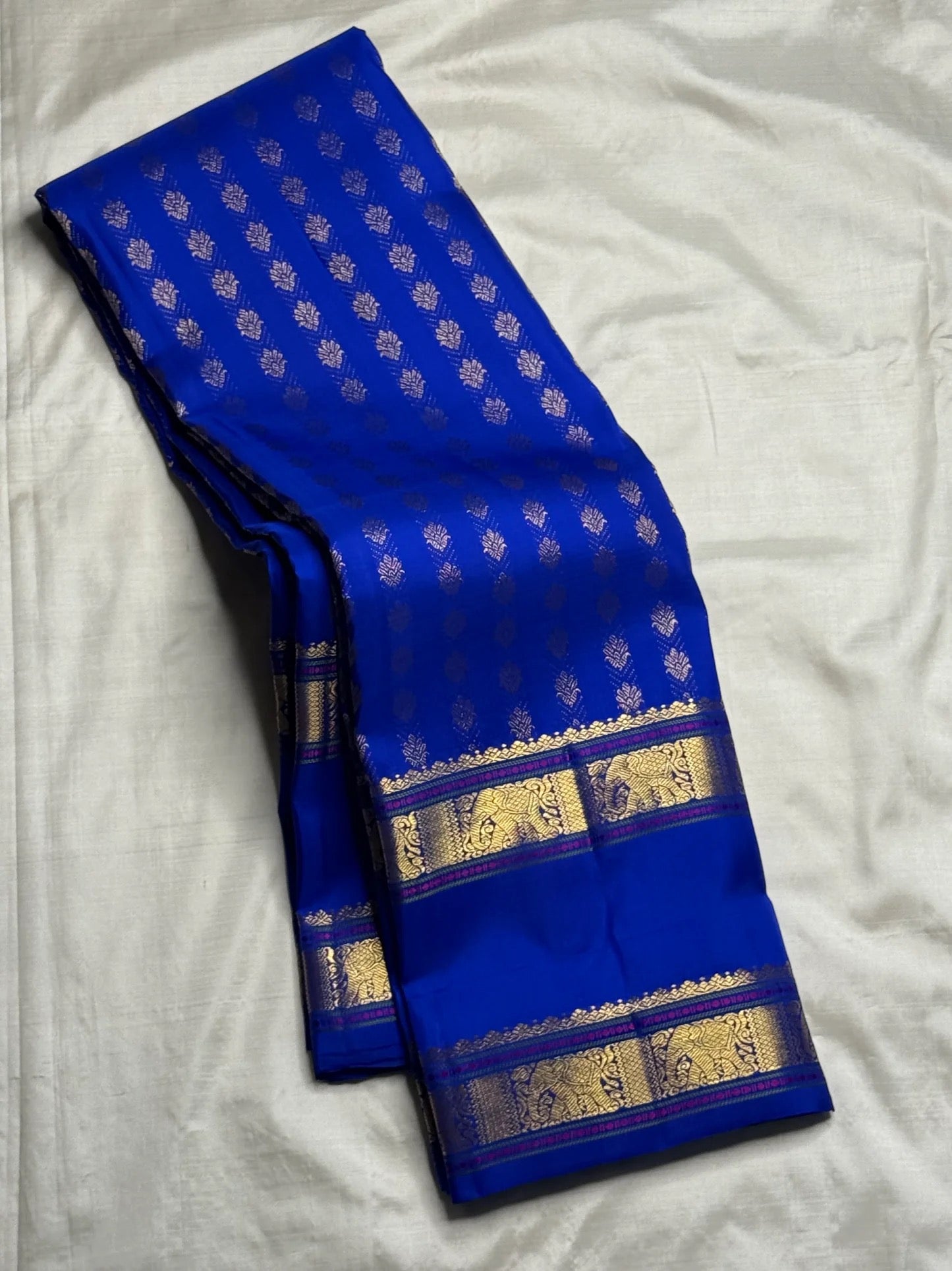 Close view of antique gold floral buttas on Royal Blue Kanjivaram silk