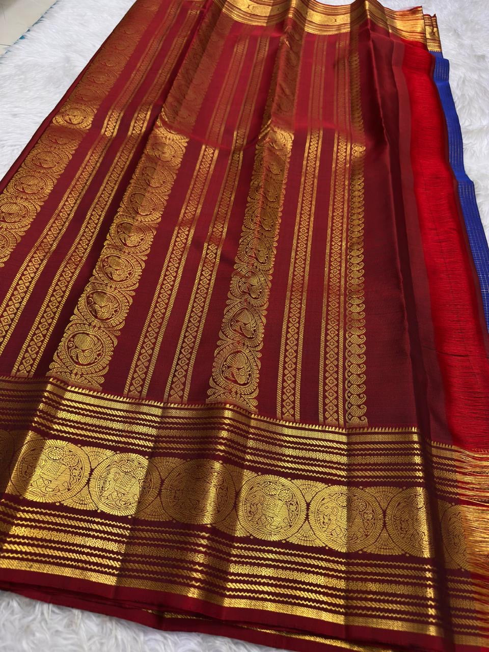 Broad traditional red border framing a royal blue silk saree