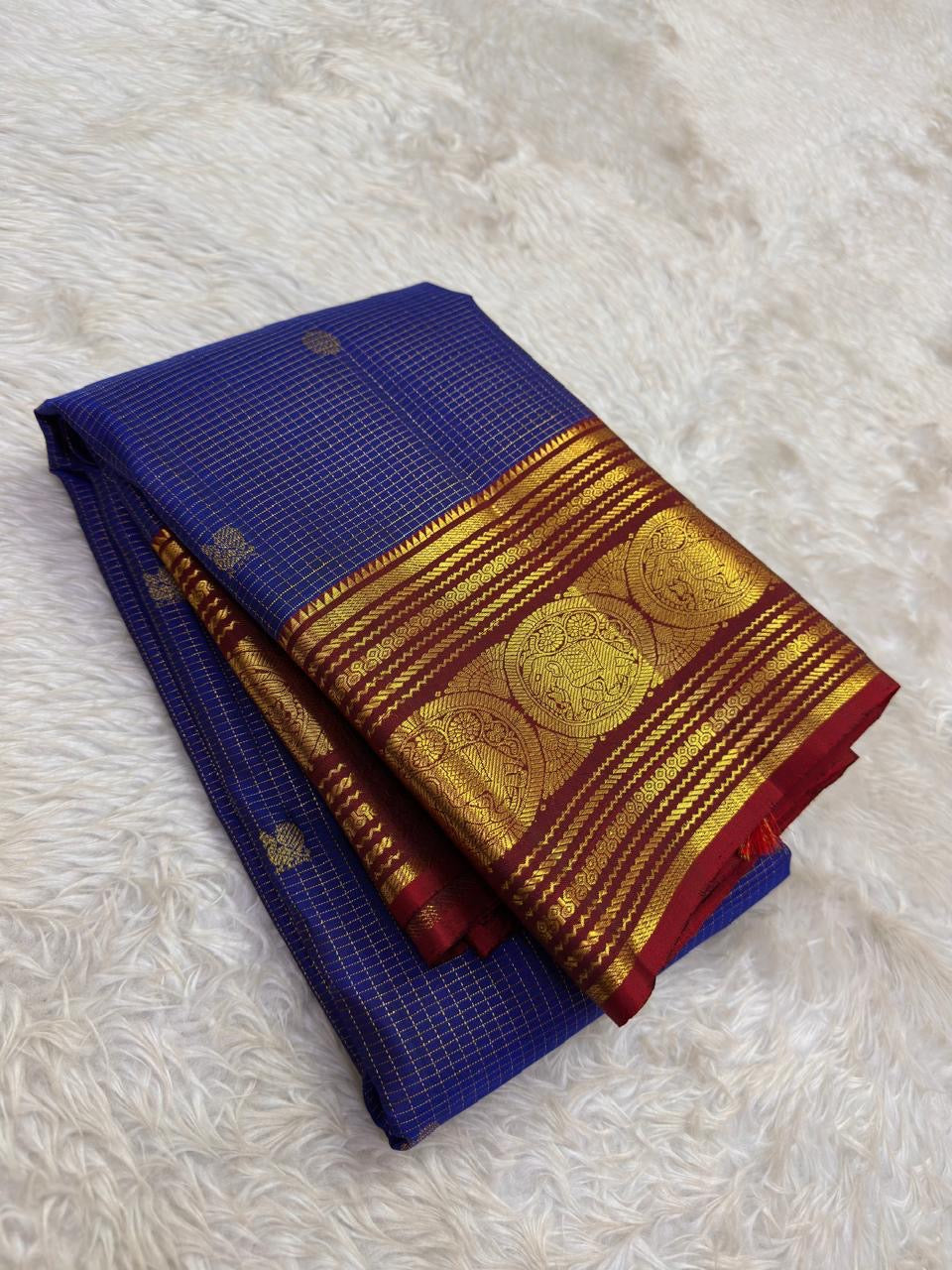 Royal blue handwoven Pure Silk Kanchipuram saree folded to show the ruby red border