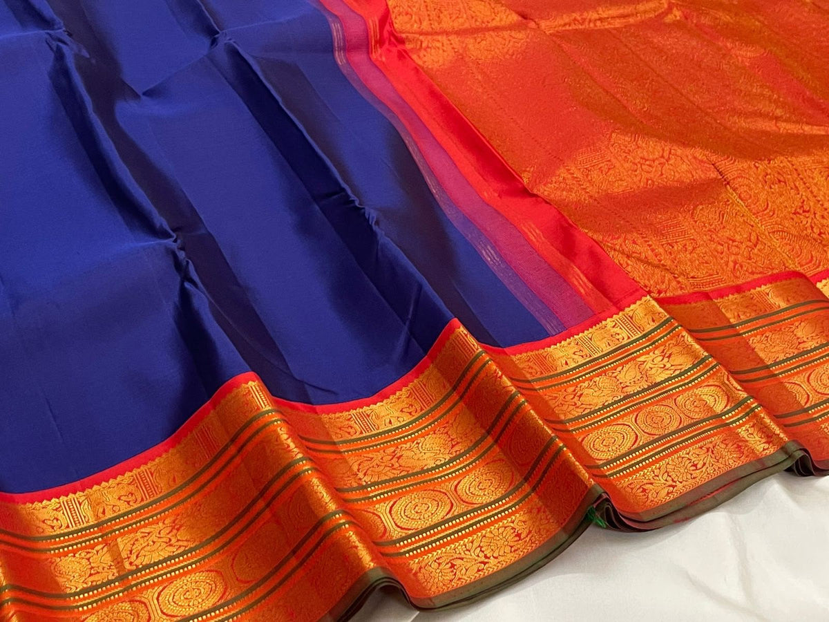 Saturated Neelam-blue Kanchipuram silk body with a plain open field and strong contrast border.