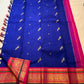Folded Royal Blue Korvai silk showing vivid Rani Pink stacked border with green bands and gold zari.