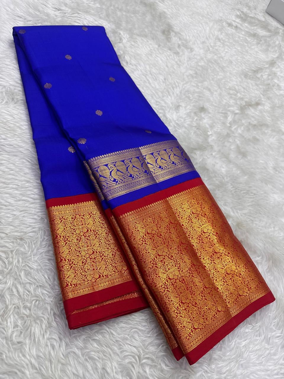 Neelam blue Pure Silk Kanjeevaram Butta saree with spaced gold-zari motifs and vermilion-red grand border.
