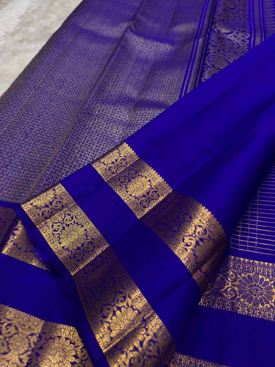 Royal blue Kancheepuram silk saree body close-up showing Zari Kattam luminous grid and Mayil Chakram gold zari butta motifs