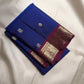 Handwoven Royal Blue Kanchipuram silk saree with antique-gold zari buttas and purple border.