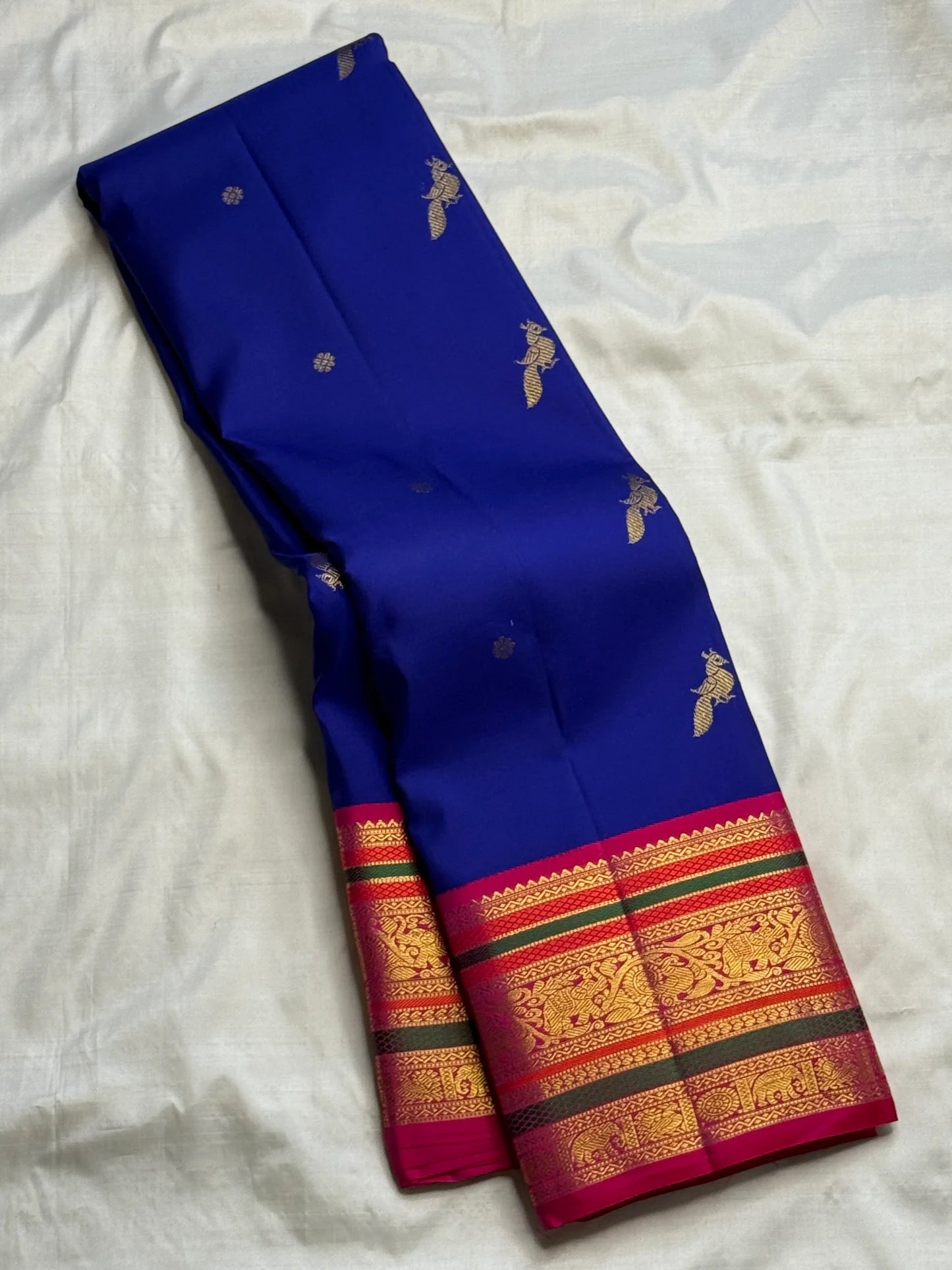 Close view of Royal Blue Korvai saree, Rani Pink pallu and layered green-and-gold zari border.