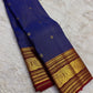 Rich ruby red border with bold circular zari medallions on a blue silk saree