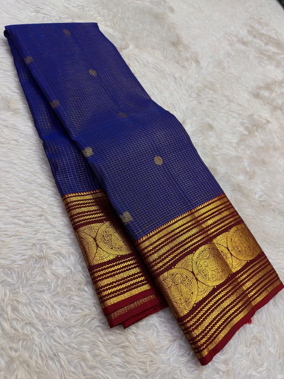 Rich ruby red border with bold circular zari medallions on a blue silk saree