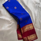 Pure Kanchipuram silk saree in royal blue with scattered round silver motifs and a maroon zari woven border along the edge.