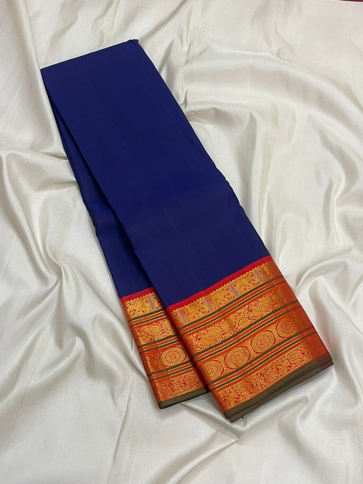 Burnt-orange Kanchipuram pallu with dense vertical classic-gold zari registers and ornamental woven forms.
