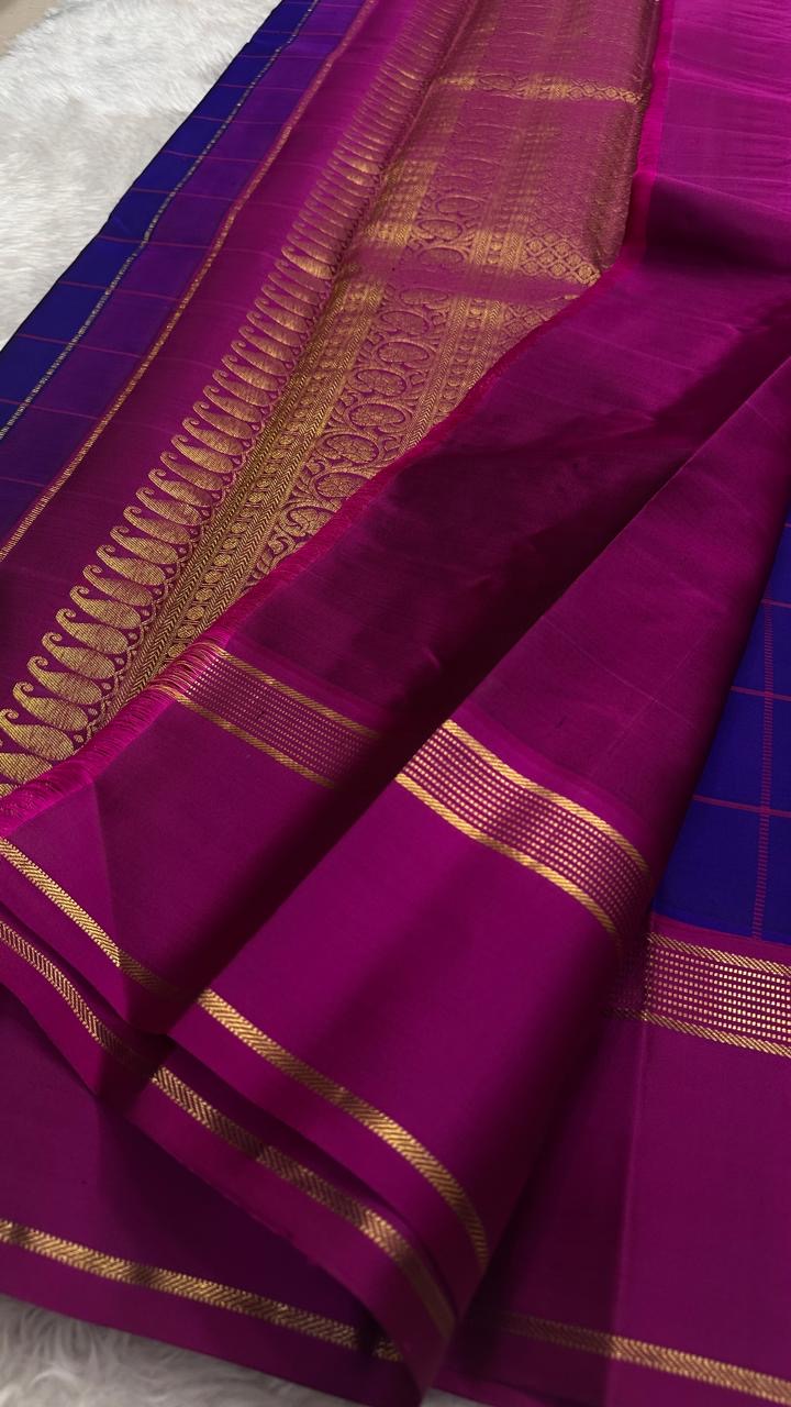 Jewel blue Kanjivaram silk with pink contrast border.