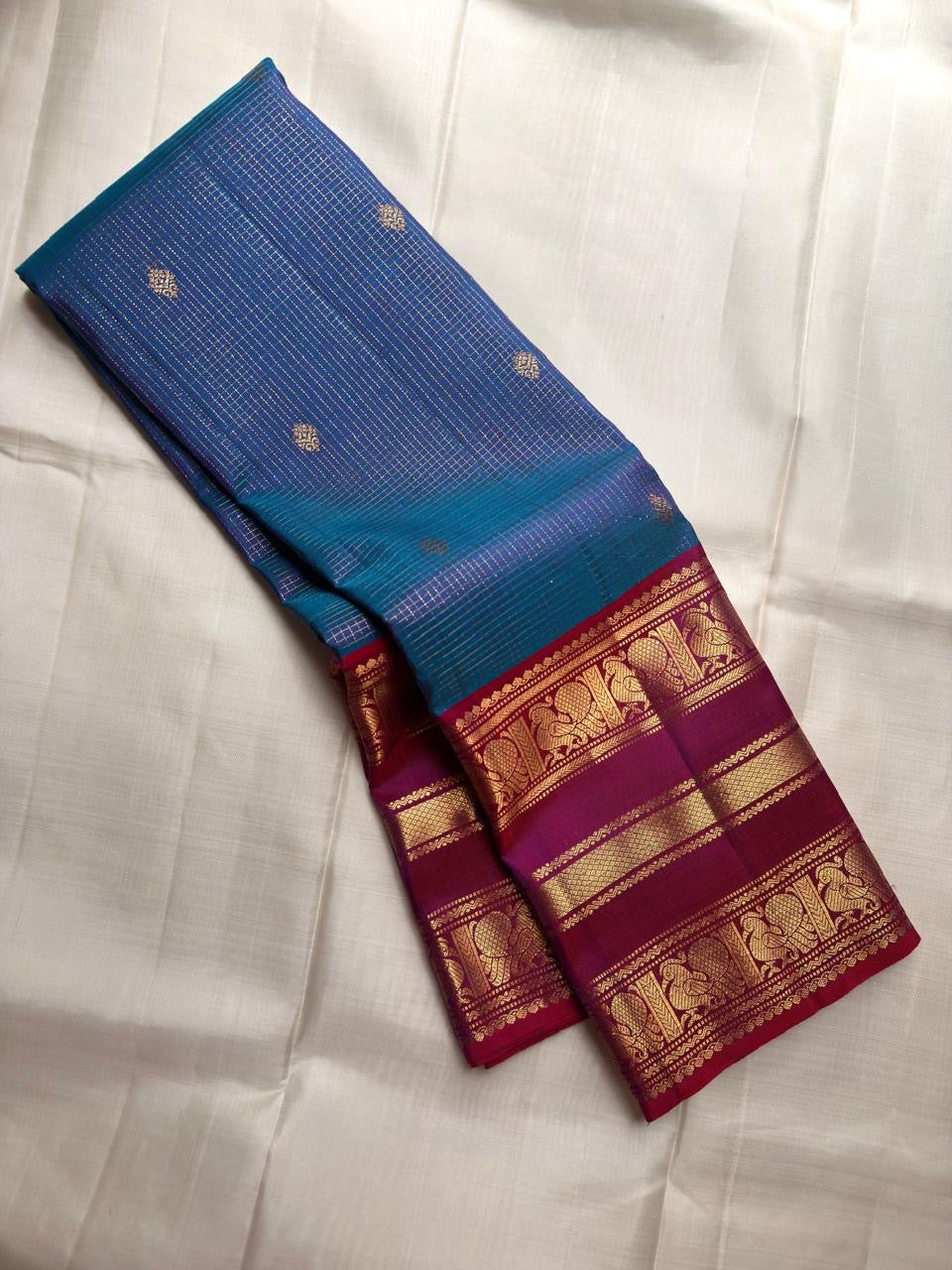 Magenta Varisaipet border detail with gold zari elephant and peacock motifs on royal blue Kancheepuram silk saree