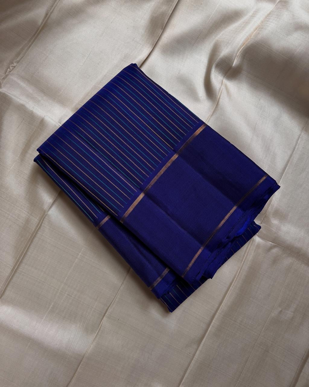 Deep sapphire blue handwoven Kanchipuram silk saree with fine zari pinstripes and luxurious silk finish