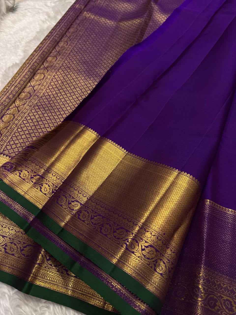 Purple pure silk Kanjivaram Butta saree with broad antique-gold zari border.