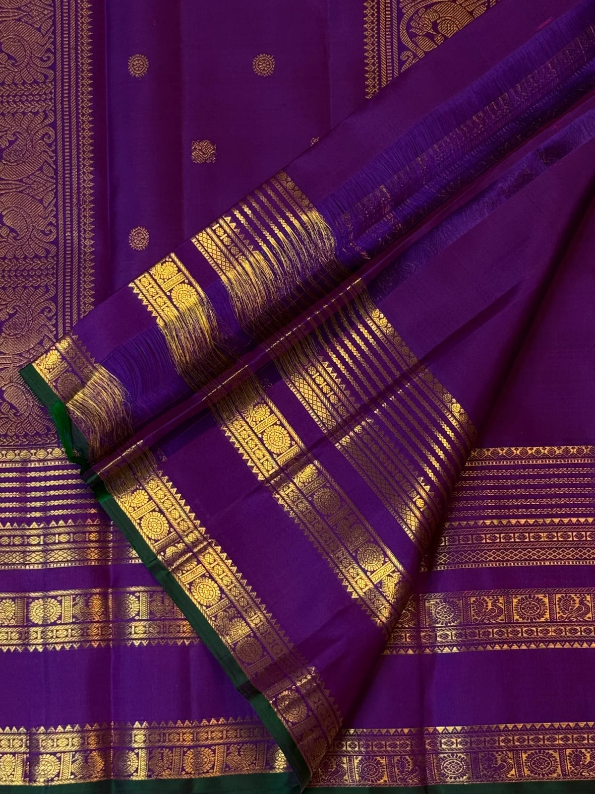 Close view of royal violet Zari Kattam silk framed by a multi-register gold border and deep-green selvedge.