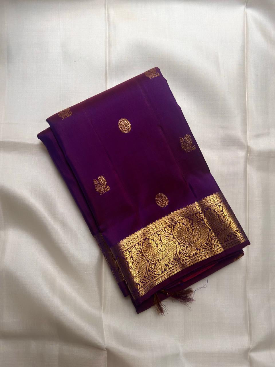 Close view of antique gold zari buttas woven across Royal Purple Kanchipuram silk